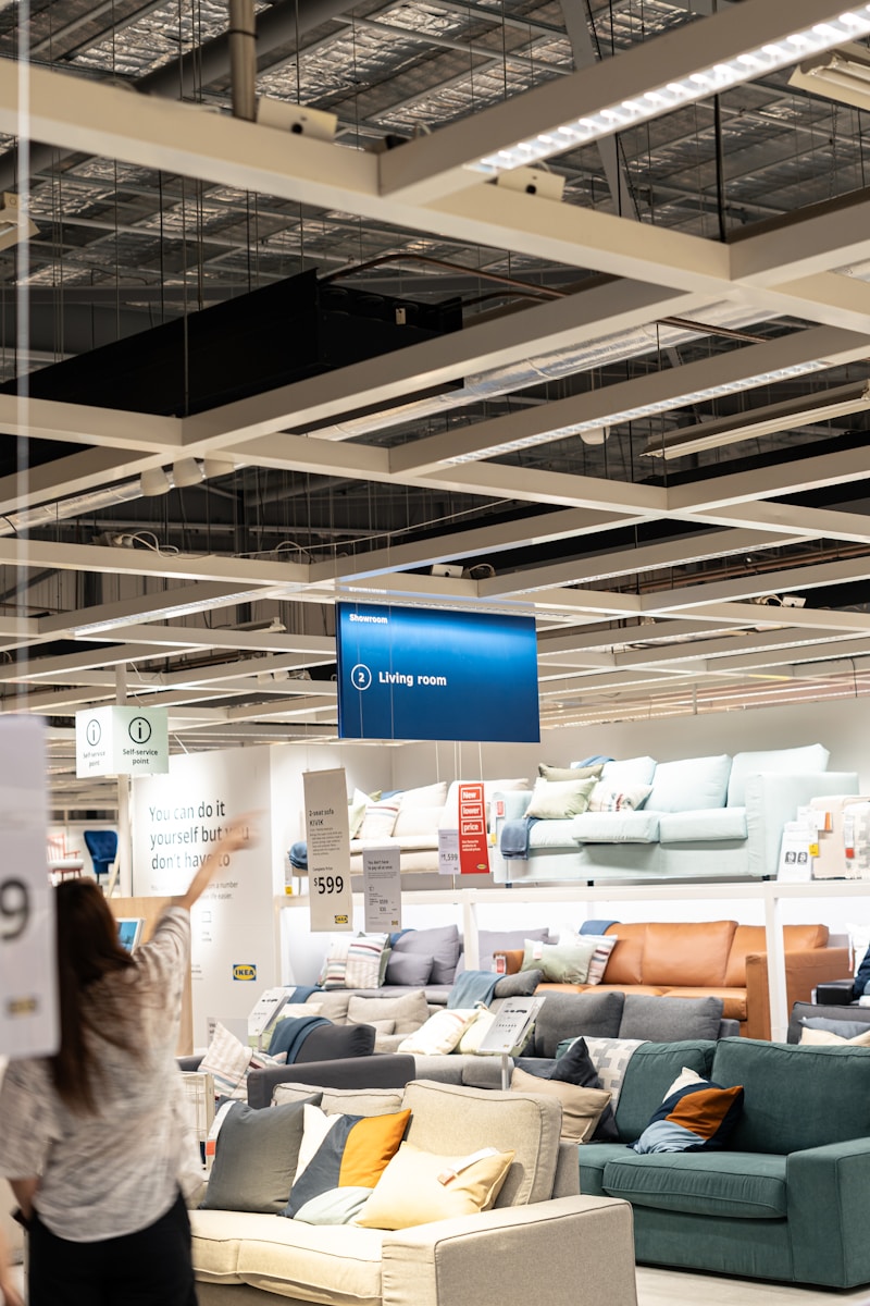 a woman holding a sign in a furniture store