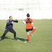 a couple of people on a field with a soccer ball