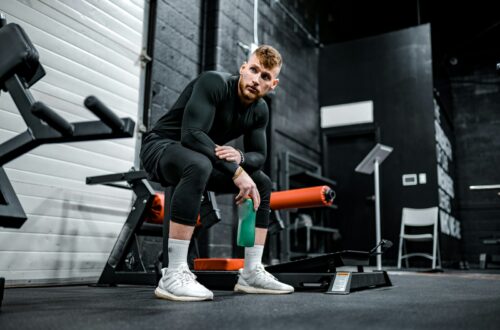 woman in black long sleeve shirt and black pants sitting on exercise equipment